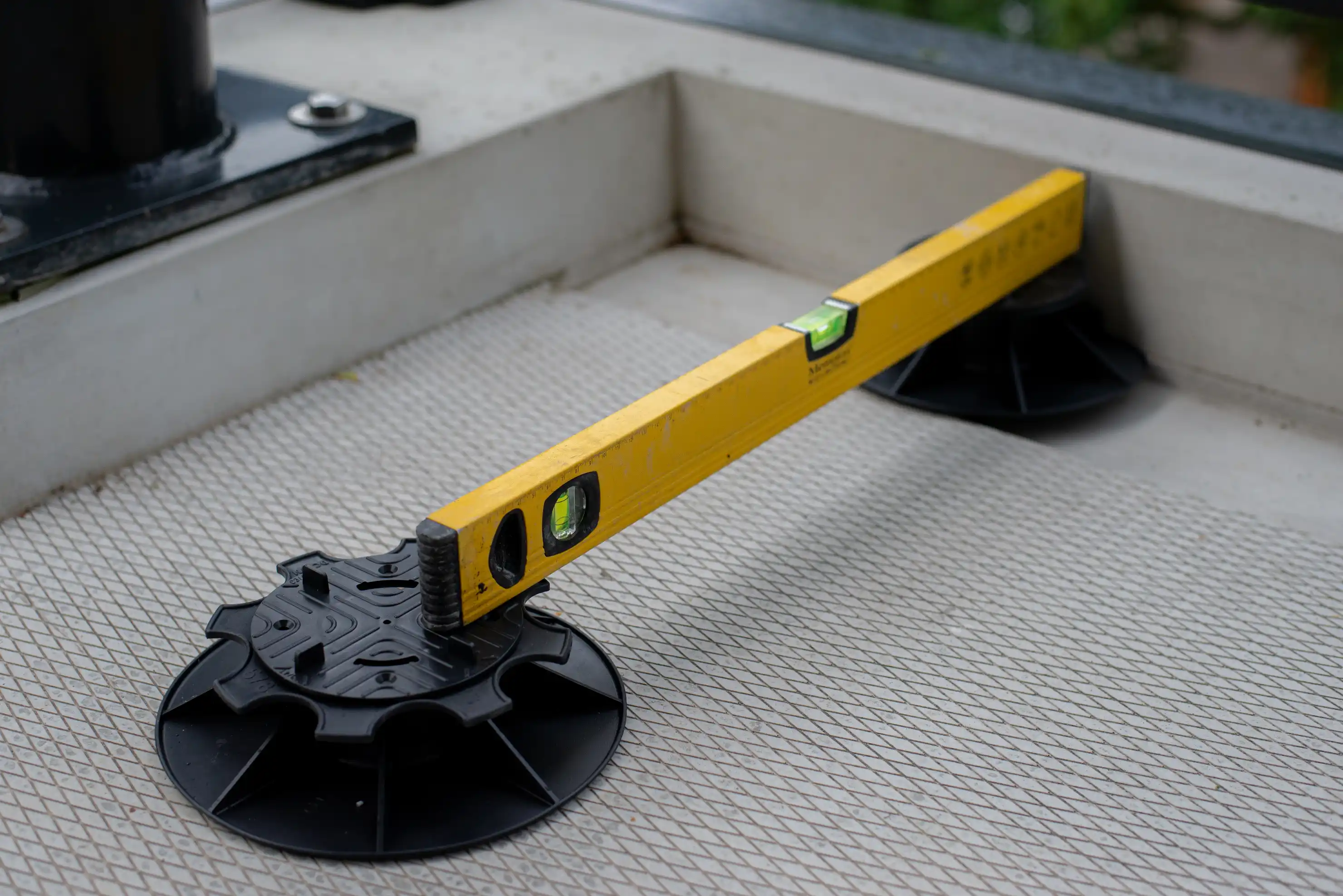 Tegeldragers op nieuw balkon met waterpas